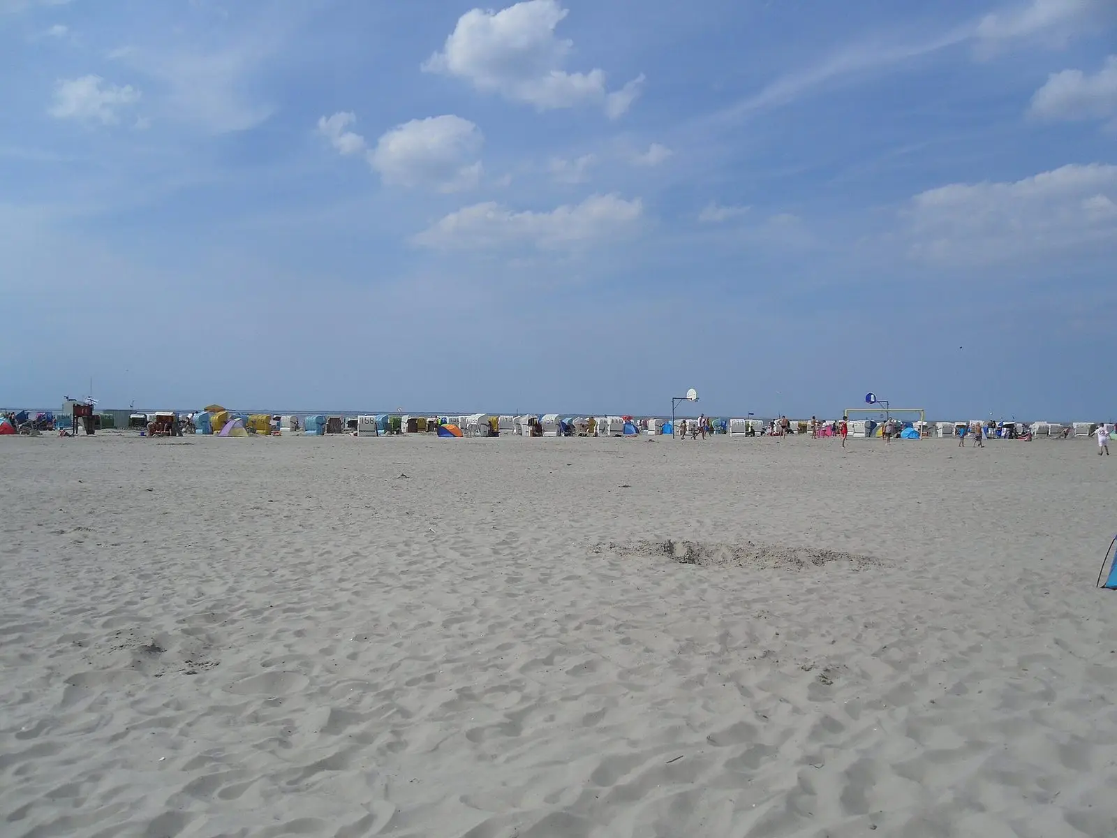 Breiter Sandstrand in Norddeich mit Strandkörben in der Ferne