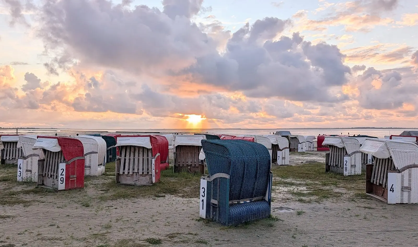 Strandkörbe am Strand von Bensersiel im Licht der aufgehenden Sonne