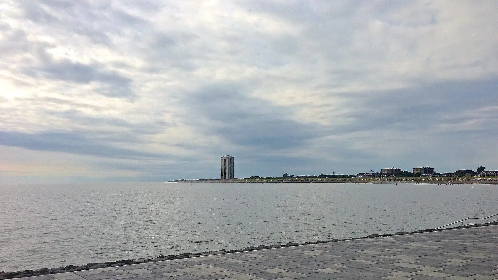 Blick vom Deich am Büsumer Südstrand über die Nordsee bis zum Hochhaus