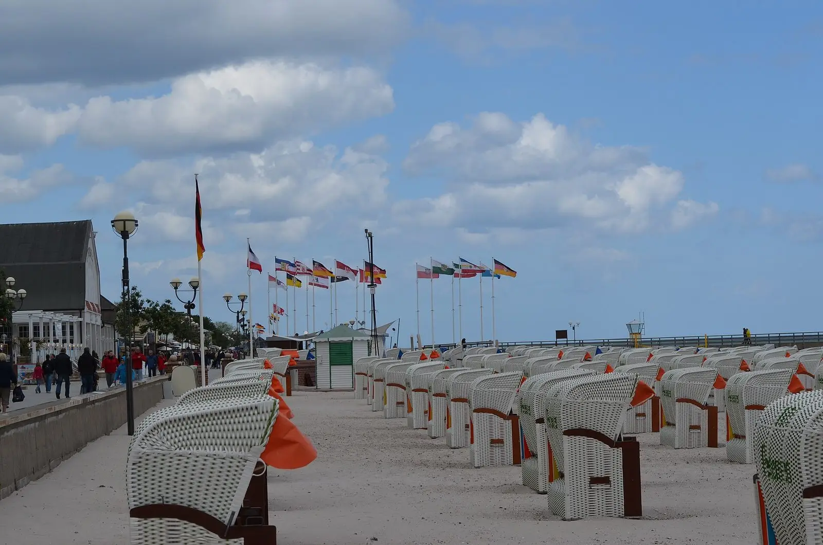 Strandpromenade von Grömitz mit Fahnen und Strandkörben, Blick zur Seebrücke