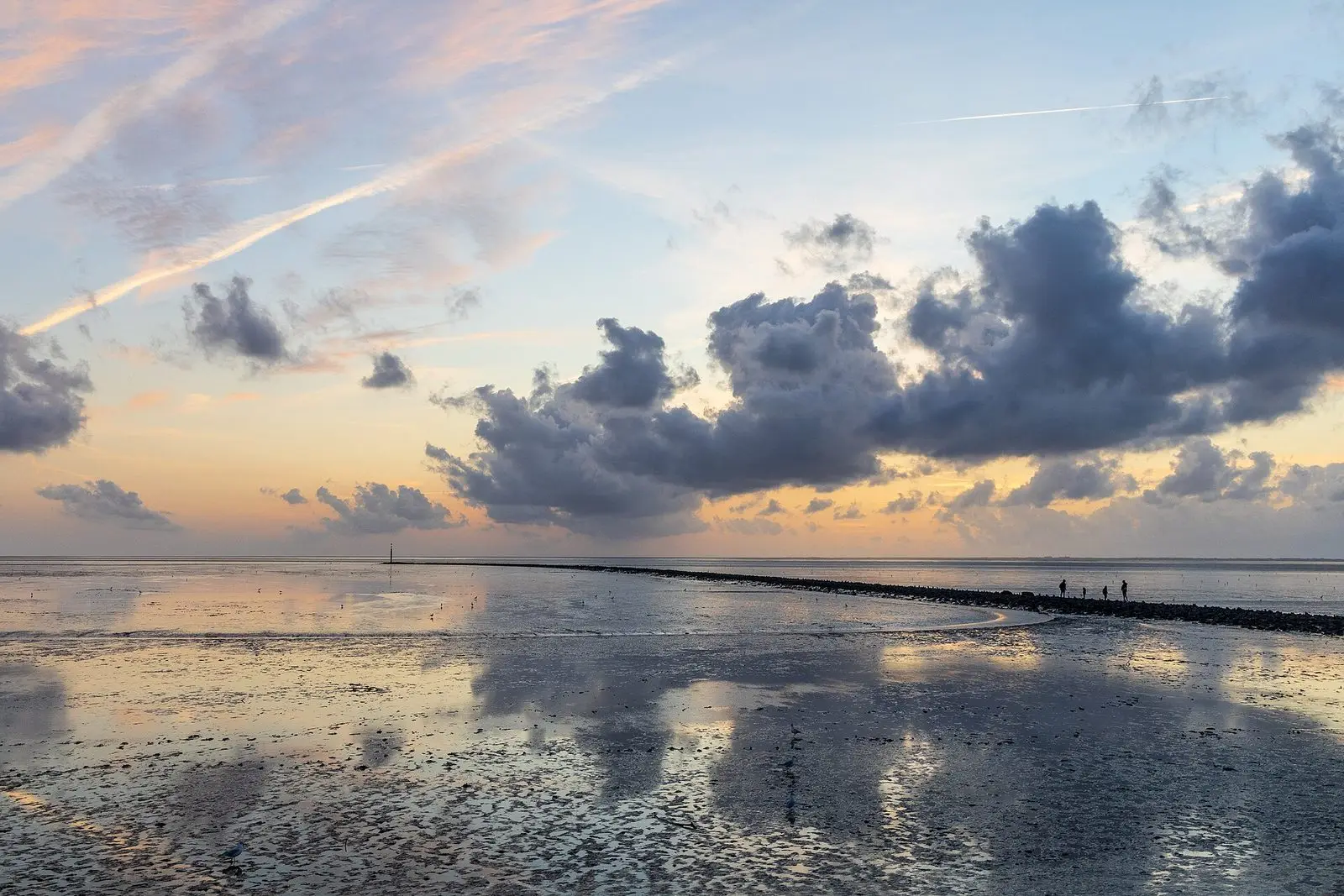 Abendstimmung im Watt vor Norddeich mit spiegelnden Wolken und Leitdamm