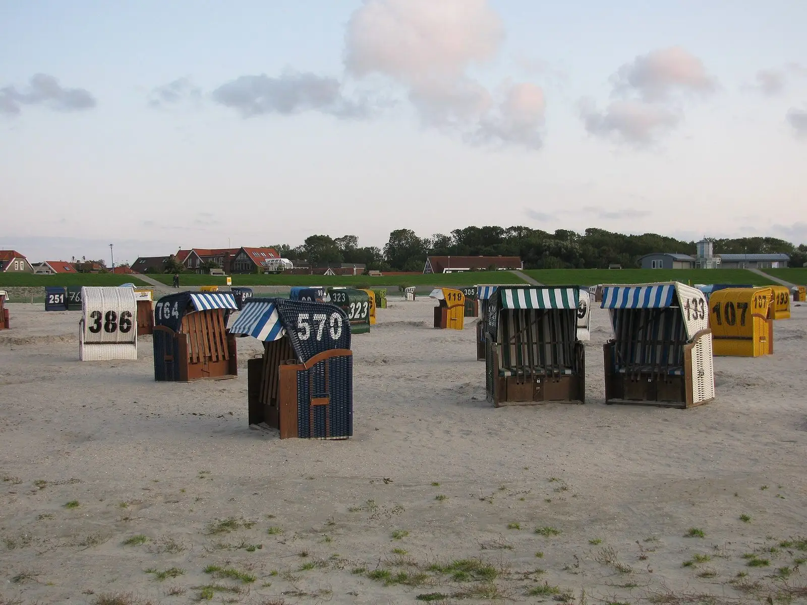 Strandkörbe am Sandstrand von Neuharlingersiel vor dem Deich