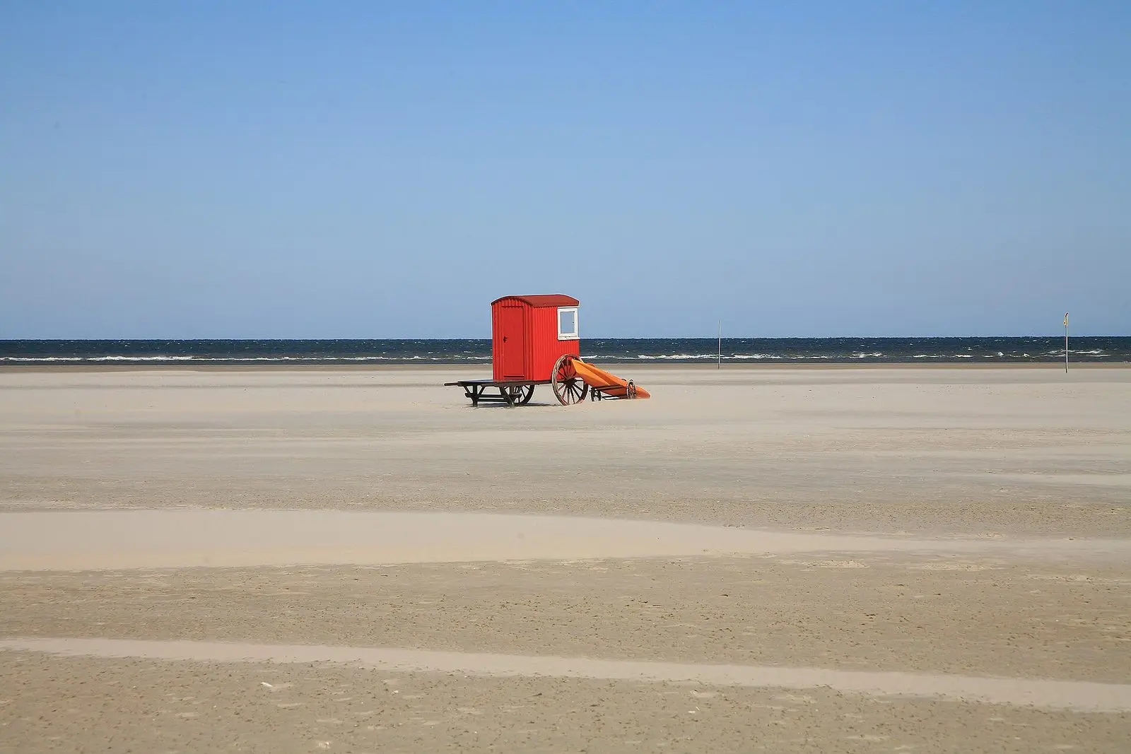 Weiter Strand von Borkum mit rotem Rettungsschwimmerhäuschen