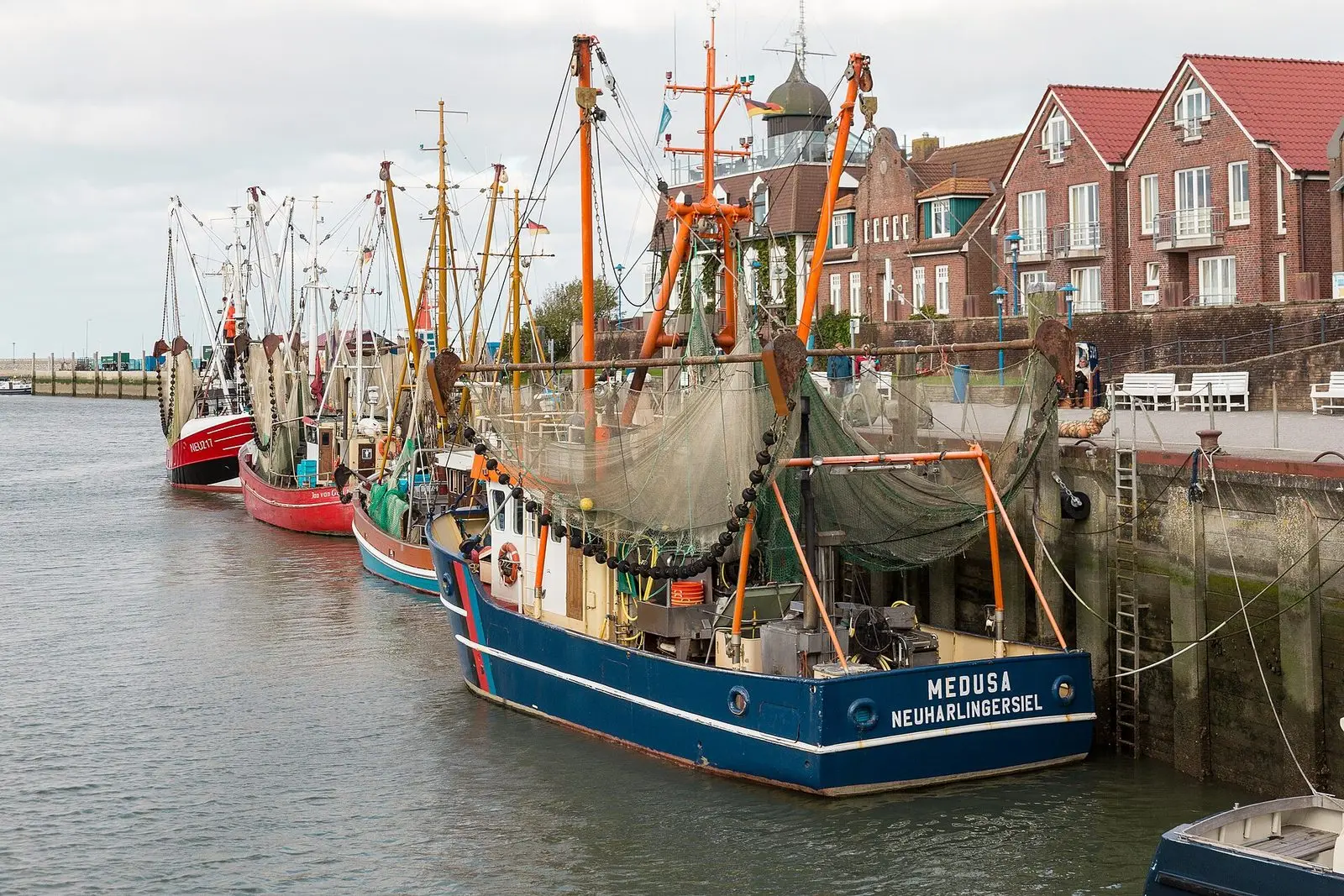 Bunte Krabbenkutter mit Netzen im Hafen von Neuharlingersiel